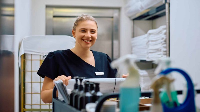 Young,Happy,Hotel,Housekeeper,At,Work,Looking,At,Camera.