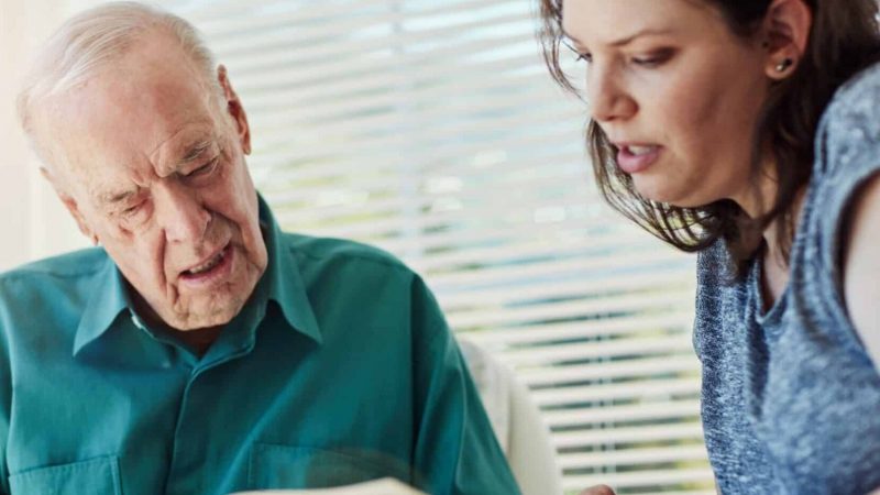 Elderly,Father,,Daughter,And,Looking,At,Photo,Album,With,Retirement,